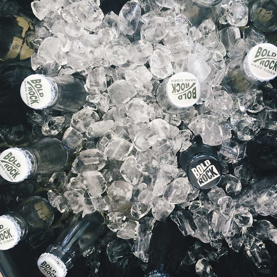 Bottles of Bold Rock Hard Cider on ice, viewed from above.