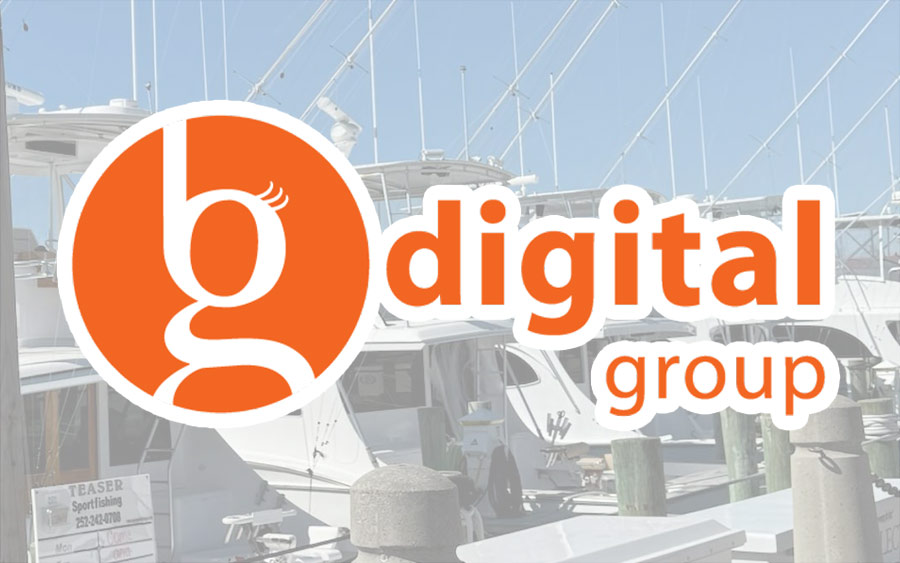 Orange "b digital group" logo overlaid on a photo of boats docked at a marina under a clear sky.